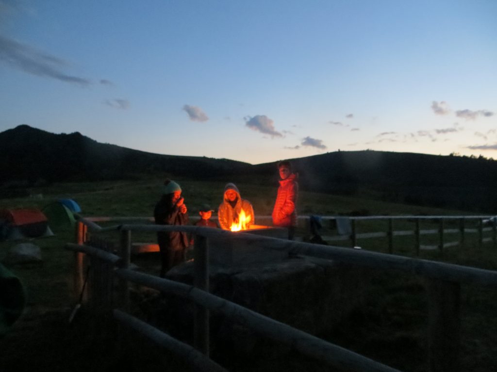 Feu de camp au refuge sur le pic de Madres, avec deux personnes autour